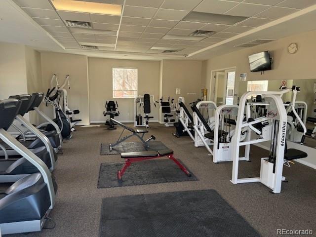 workout area featuring a paneled ceiling, visible vents, and baseboards