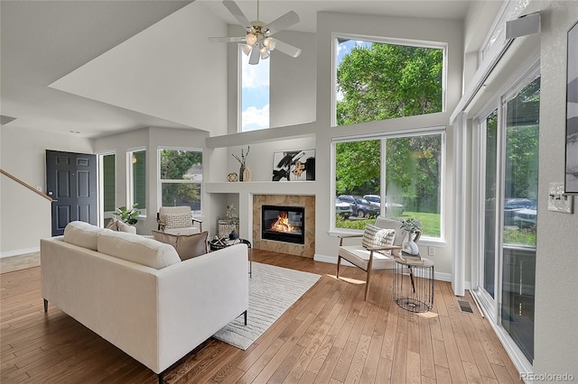1229 James Cir Unit 1, Lafayette, CO 80026 - living room featuring a towering ceiling, ceiling fan, a fireplace, and wood-type flooring