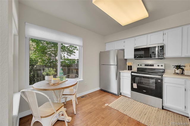 1229 James Cir Unit 1, Lafayette, CO 80026 - kitchen featuring appliances with stainless steel finishes, light countertops, white cabinets, and light wood-type flooring