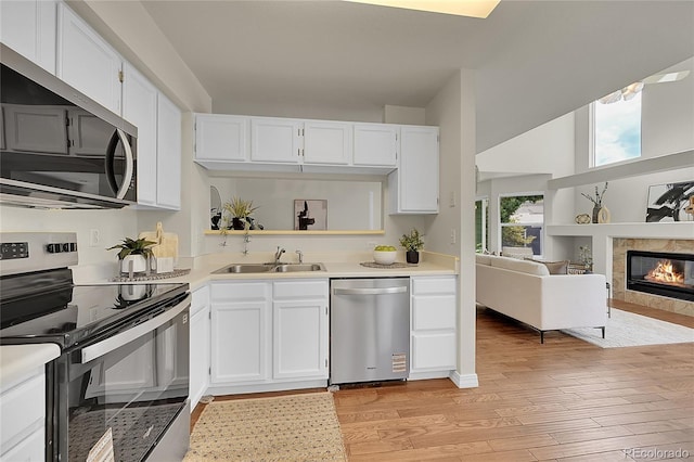 1229 James Cir Unit 1, Lafayette, CO 80026 - kitchen with appliances with stainless steel finishes, light wood finished floors, light countertops, and white cabinetry