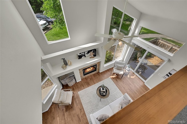 1229 James Cir Unit 1, Lafayette, CO 80026 - living room with a ceiling fan, a towering ceiling, a glass covered fireplace, and wood finished floors