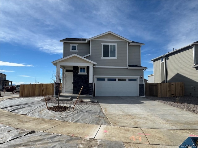 view of front facade featuring driveway, an attached garage, and fence