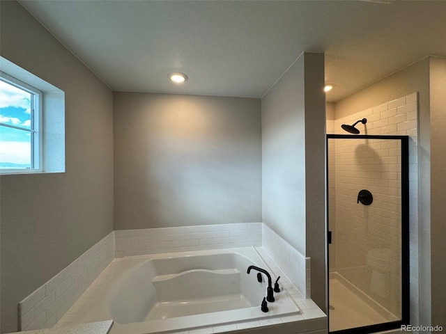 bathroom featuring a stall shower and a garden tub