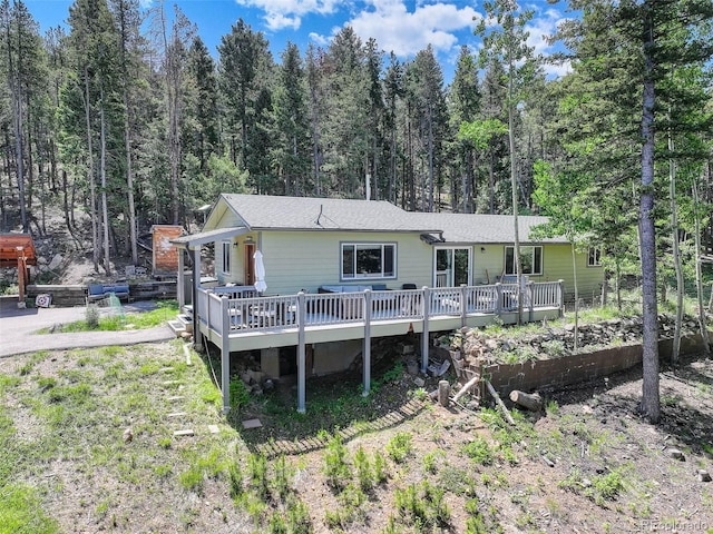 8340 London Ln, Conifer, CO 80433 - rear view of house with a wooden deck and a view of trees