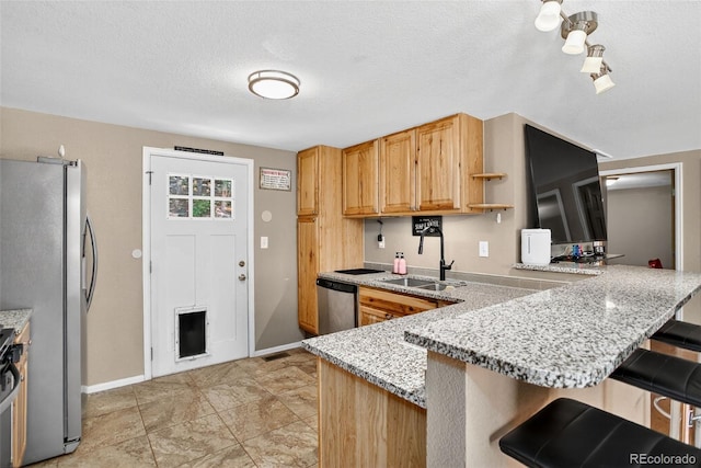 8340 London Ln, Conifer, CO 80433 - kitchen featuring stainless steel appliances, a breakfast bar, a peninsula, open shelves, and light stone countertops
