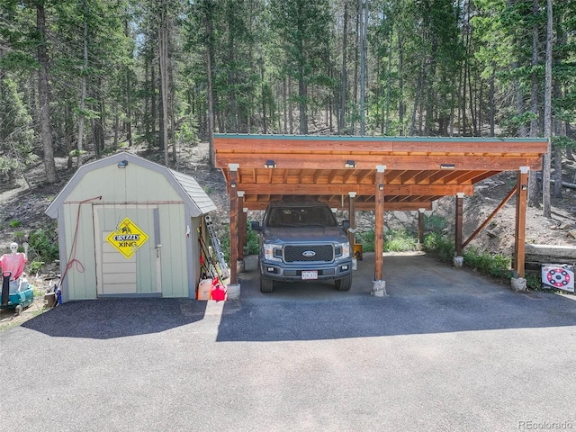 8340 London Ln, Conifer, CO 80433 - view of parking with driveway, a shed, a carport, and a forest view