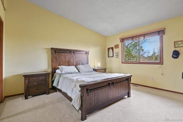 bedroom with baseboards, vaulted ceiling, and light colored carpet