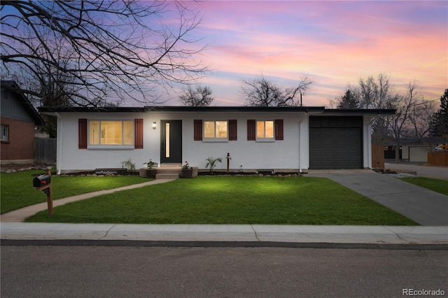 single story home with a front lawn, an attached garage, brick siding, and driveway