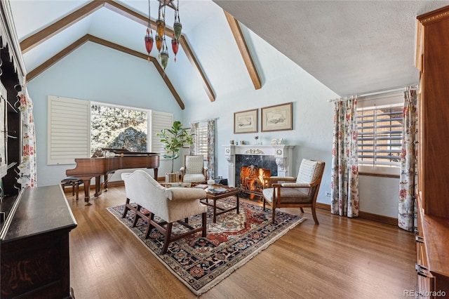 living room with hardwood / wood-style flooring, a high end fireplace, high vaulted ceiling, and a textured ceiling