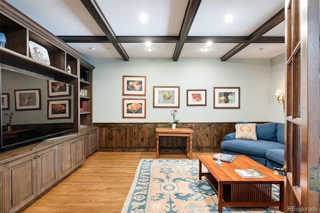 living room with beam ceiling, coffered ceiling, wooden walls, and light wood-type flooring