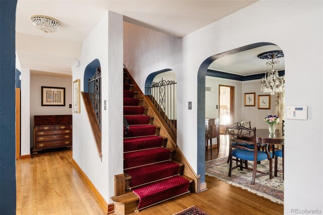 staircase with an inviting chandelier and hardwood / wood-style floors