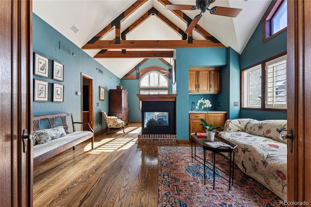 living room featuring vaulted ceiling with beams, hardwood / wood-style flooring, a healthy amount of sunlight, and ceiling fan