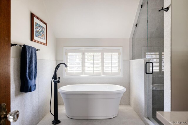 bathroom featuring tile walls, vaulted ceiling, and separate shower and tub