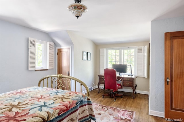 bedroom with lofted ceiling and light wood-type flooring