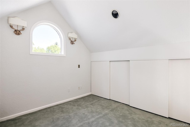 bonus room with lofted ceiling and light carpet