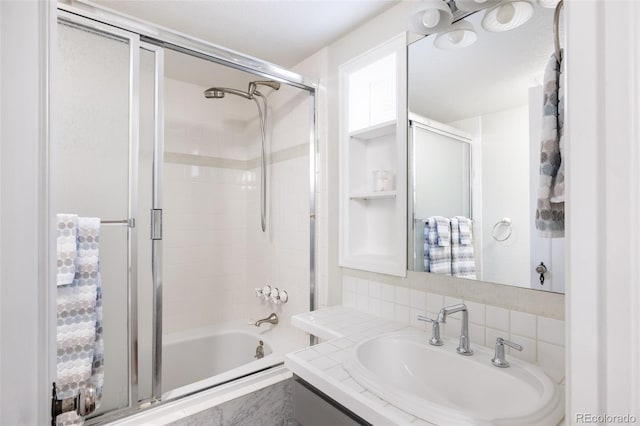 bathroom with tasteful backsplash, vanity, and combined bath / shower with glass door