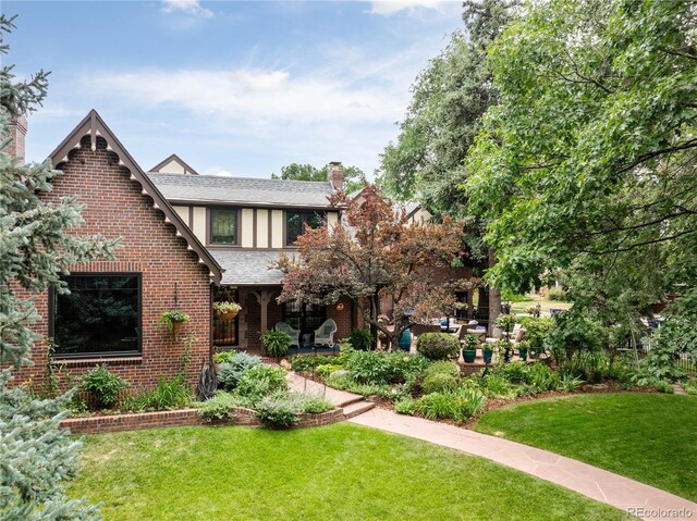 tudor home featuring a front yard and a patio