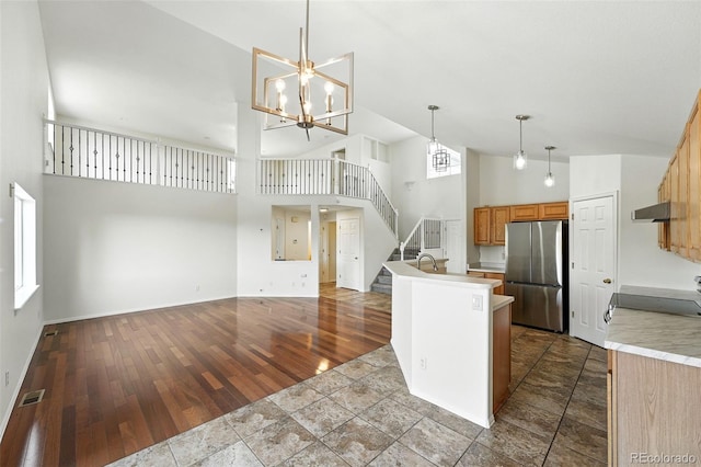 22501 E Belleview Pl, Aurora, CO 80015 - kitchen with freestanding refrigerator, high vaulted ceiling, range, light countertops, and dark wood-style floors