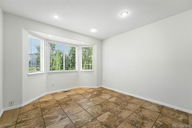 22501 E Belleview Pl, Aurora, CO 80015 - unfurnished room featuring plenty of natural light, recessed lighting, and stone finish floors