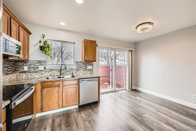 kitchen featuring plenty of natural light, appliances with stainless steel finishes, sink, and backsplash