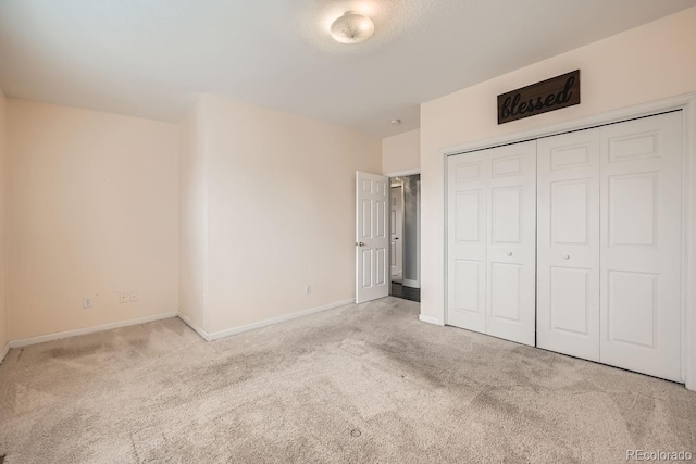 unfurnished bedroom with light carpet and a closet