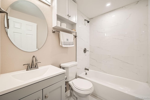 full bathroom featuring tiled shower / bath combo, vanity, and toilet