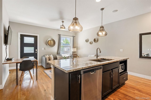 2645 W 24th Ave, Denver, CO 80211 - kitchen with stainless steel dishwasher, light wood-style flooring, hanging light fixtures, light stone counters, and a kitchen island with sink
