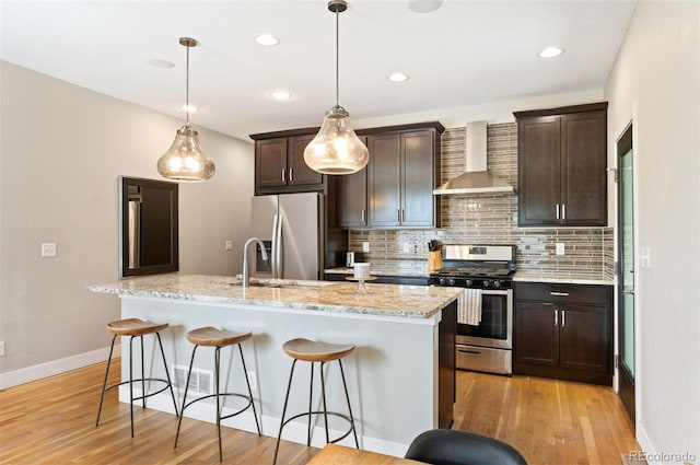 2645 W 24th Ave, Denver, CO 80211 - kitchen with wall chimney exhaust hood, stainless steel appliances, backsplash, a kitchen breakfast bar, and recessed lighting