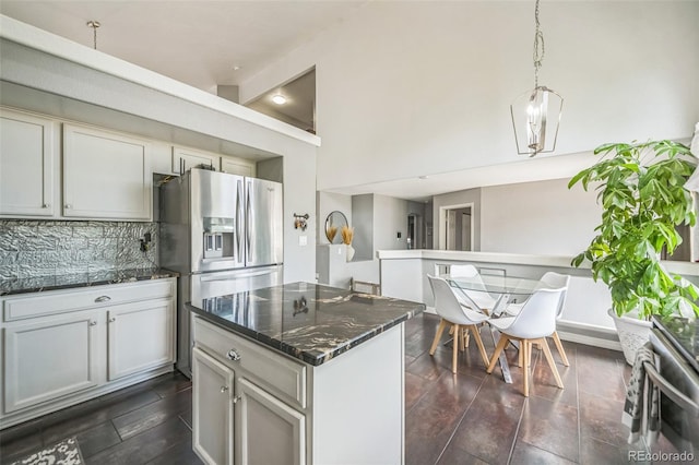 20338 E 48th Dr, Denver, CO 80249 - kitchen featuring stainless steel fridge with ice dispenser, backsplash, dark stone countertops, a center island, and hanging light fixtures