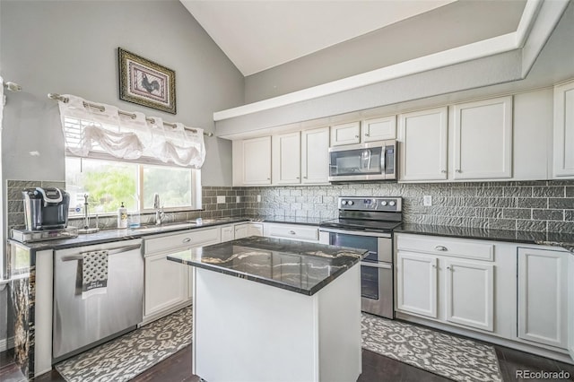 20338 E 48th Dr, Denver, CO 80249 - kitchen with stainless steel appliances, a sink, vaulted ceiling, tasteful backsplash, and a center island