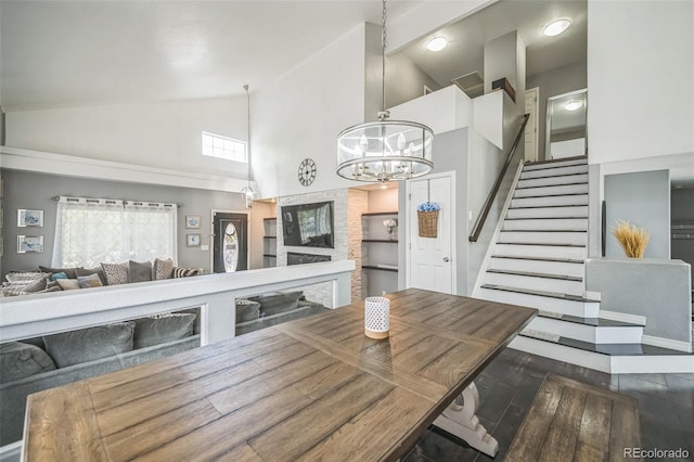 20338 E 48th Dr, Denver, CO 80249 - dining room featuring high vaulted ceiling, a chandelier, stairs, and wood finished floors