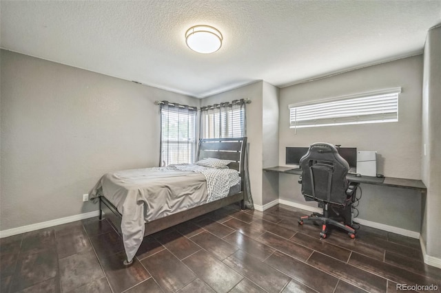 20338 E 48th Dr, Denver, CO 80249 - bedroom featuring multiple windows, baseboards, an office area, and a textured ceiling