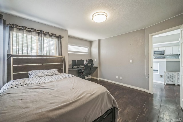 20338 E 48th Dr, Denver, CO 80249 - bedroom with wood finished floors, a textured ceiling, and baseboards