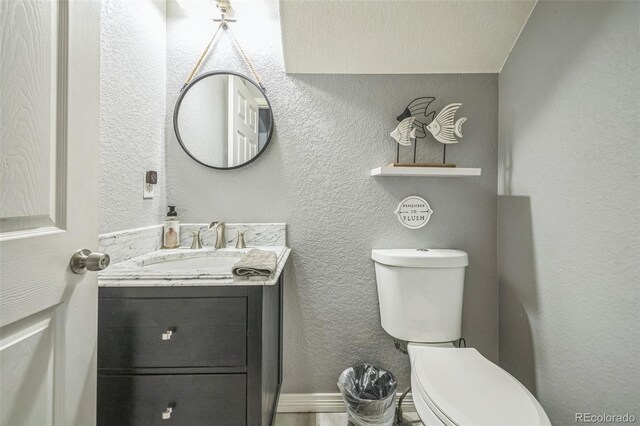 20338 E 48th Dr, Denver, CO 80249 - bathroom featuring toilet, vanity, and a textured wall