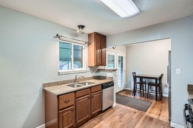 921 Dakin St, Denver, CO 80221 - kitchen featuring stainless steel dishwasher, a textured wall, light wood finished floors, french doors, and a textured ceiling