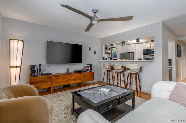 living room with ceiling fan and light hardwood / wood-style floors