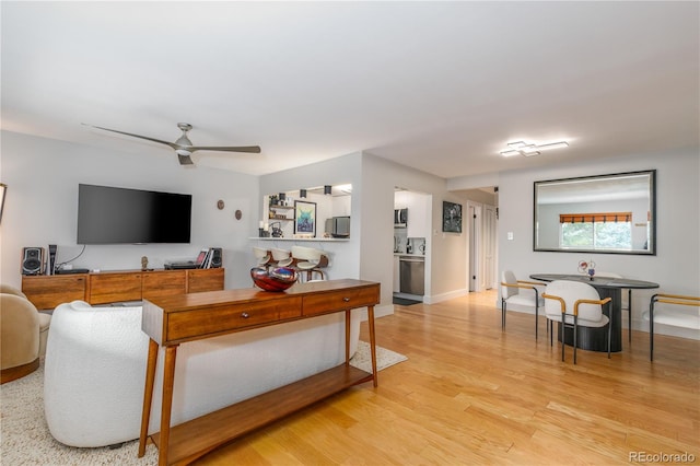 living room featuring ceiling fan and light hardwood / wood-style flooring