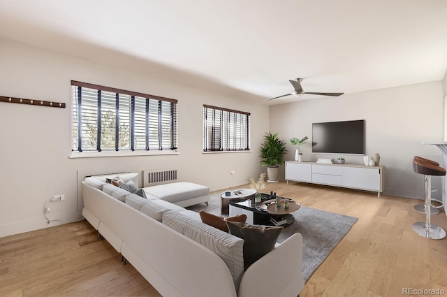 living room with ceiling fan and light hardwood / wood-style flooring