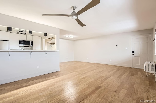 unfurnished living room with ceiling fan and light hardwood / wood-style flooring