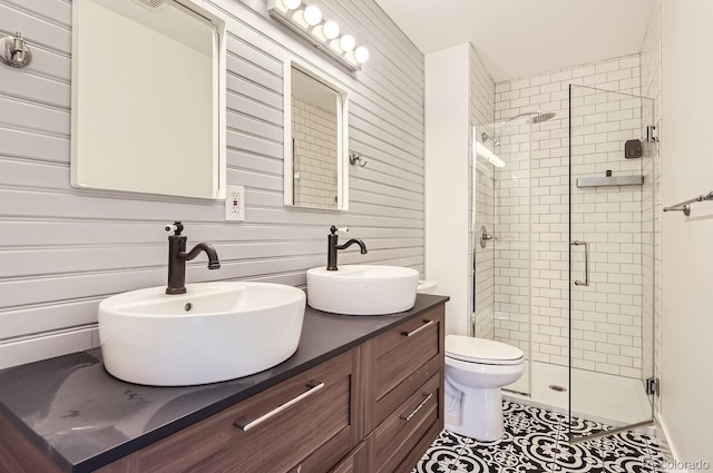 bathroom featuring tile patterned floors, vanity, toilet, and a shower with door