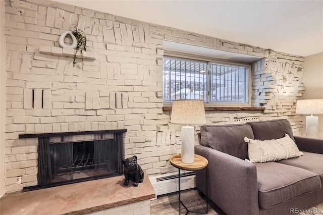 living area with a brick fireplace and baseboard heating