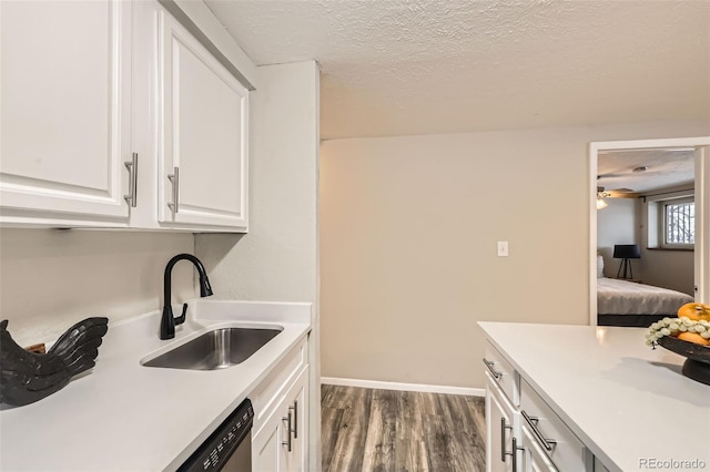 kitchen with sink, dark wood-type flooring, white cabinets, and a textured ceiling