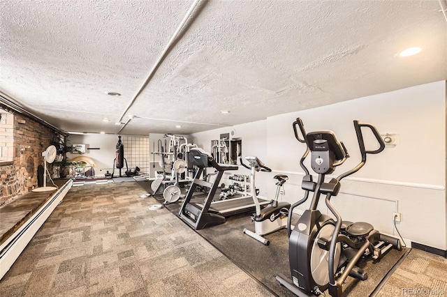 gym with a textured ceiling and a baseboard heating unit