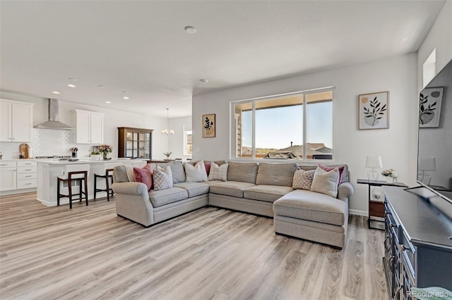 living area featuring light wood finished floors, recessed lighting, and a chandelier