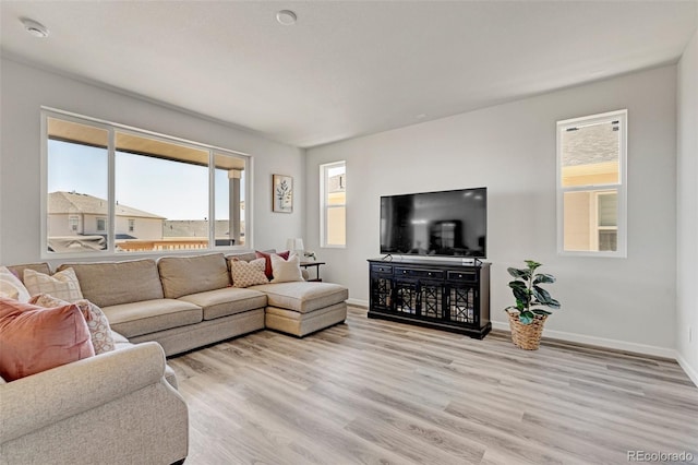 living area with light wood-style flooring and baseboards
