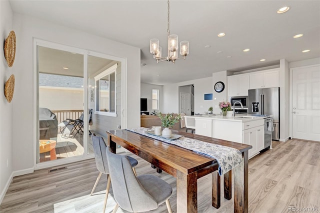 dining room with light wood-style flooring, a chandelier, recessed lighting, and baseboards