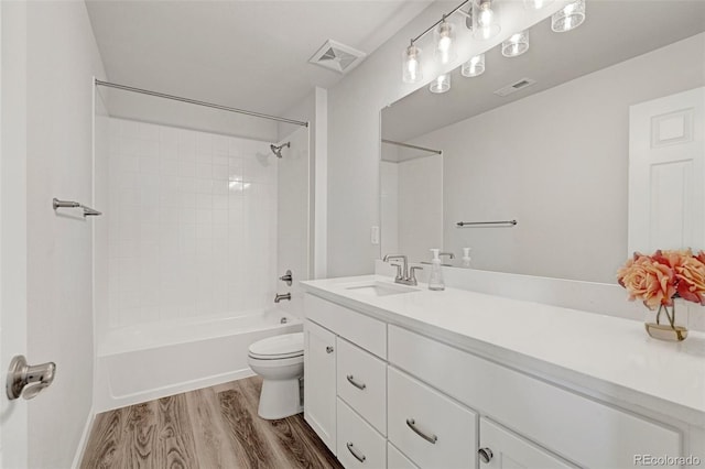 full bathroom featuring wood finished floors, toilet, vanity, and bathtub / shower combination