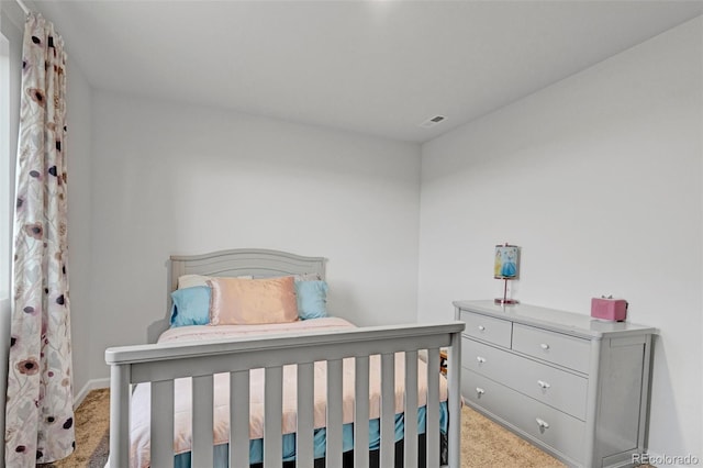 bedroom with light colored carpet and baseboards