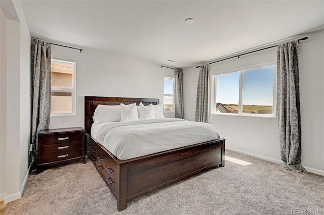 bedroom with baseboards and light carpet