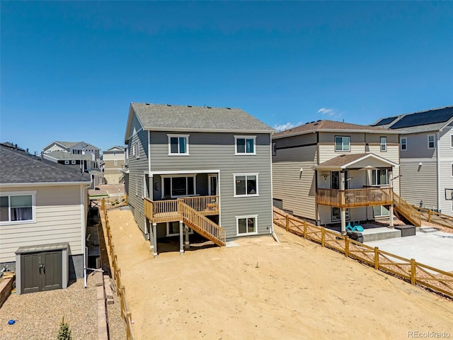 rear view of house featuring a residential view, stairs, and a fenced backyard